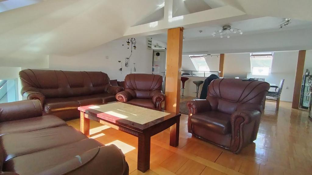 a living room with leather furniture and a table at HOTEL Crystal Lights in Pirot