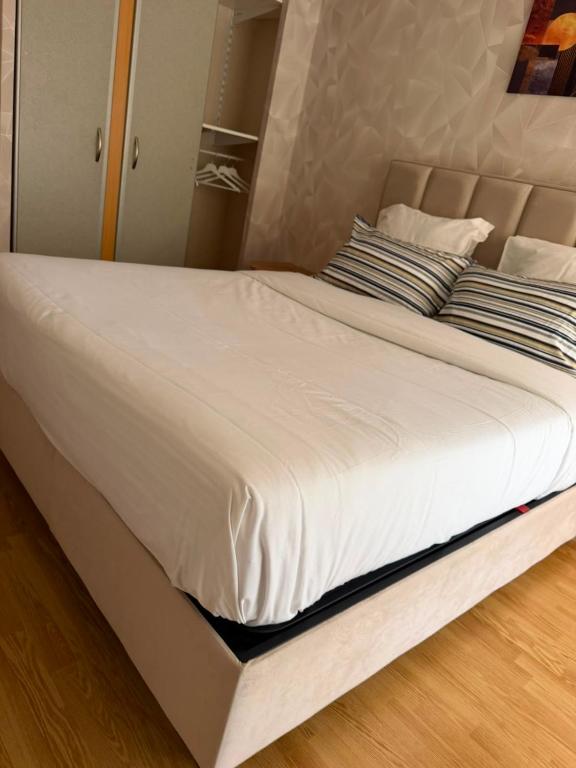 a large white bed with two pillows on it at V hotel in Savigny-le-Temple