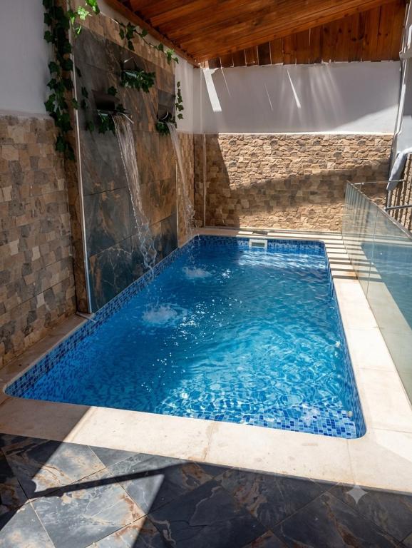 a swimming pool with a waterfall in a house at Dar mouni relax in Oran