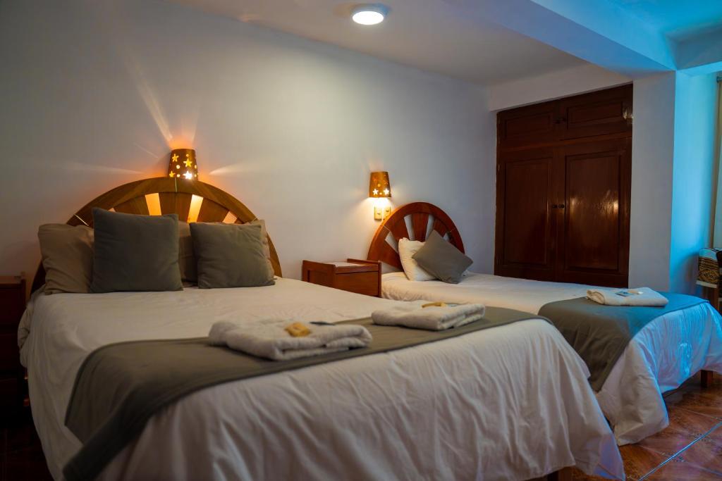 a bedroom with two beds with towels on them at Luz y Amistad - Pisac in Pisac