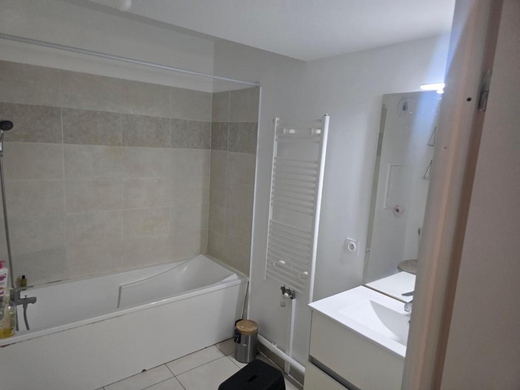 a white bathroom with a tub and a sink at Havre de paix confort,élégance in Chelles