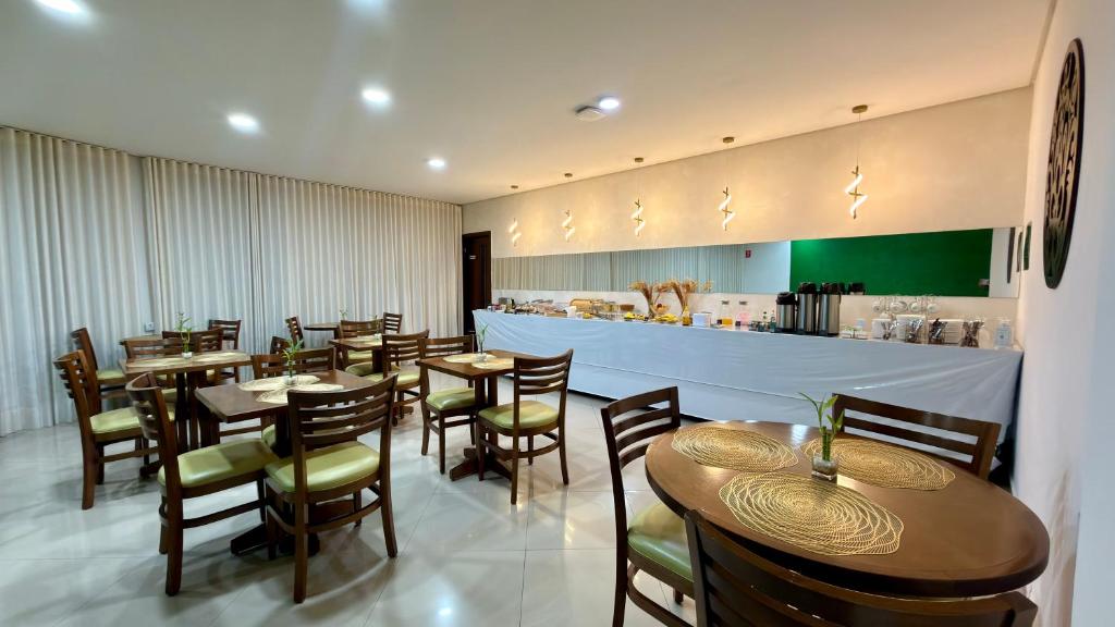 a restaurant with tables and chairs and a bar at Bela Vista Hotel in Arujá
