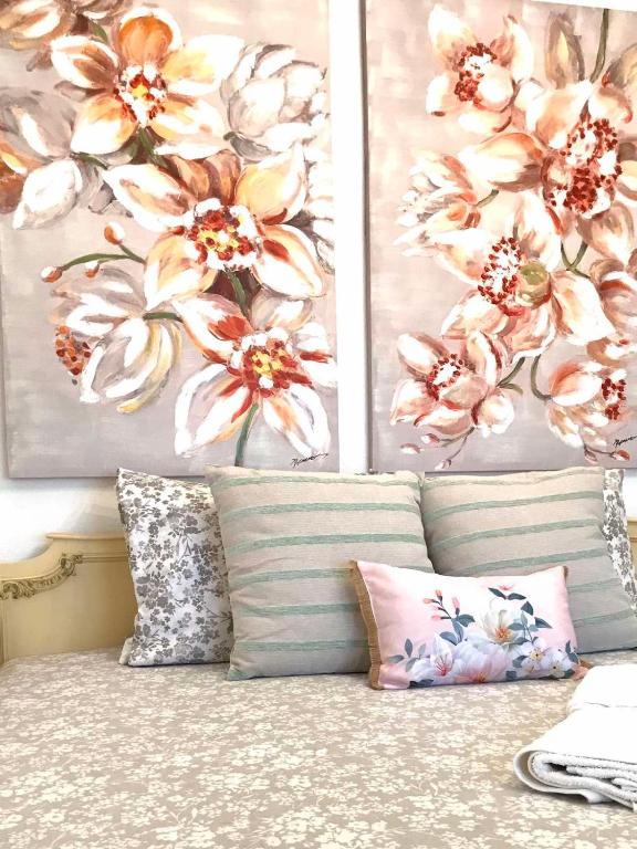 a couch with two pillows in a room with flowers at Aeria Elegant Luxury Villa in Asprovalta