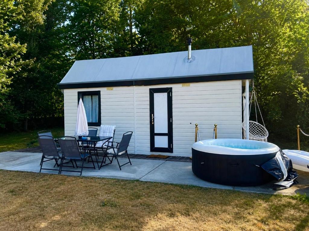 a large tub sitting next to a table and a house at No 7 Plasmolen in Middelaar