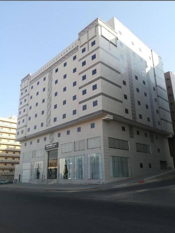a large white building on the corner of a street at شعيل ان للشقق المخدومة - اقتصادي in Mecca