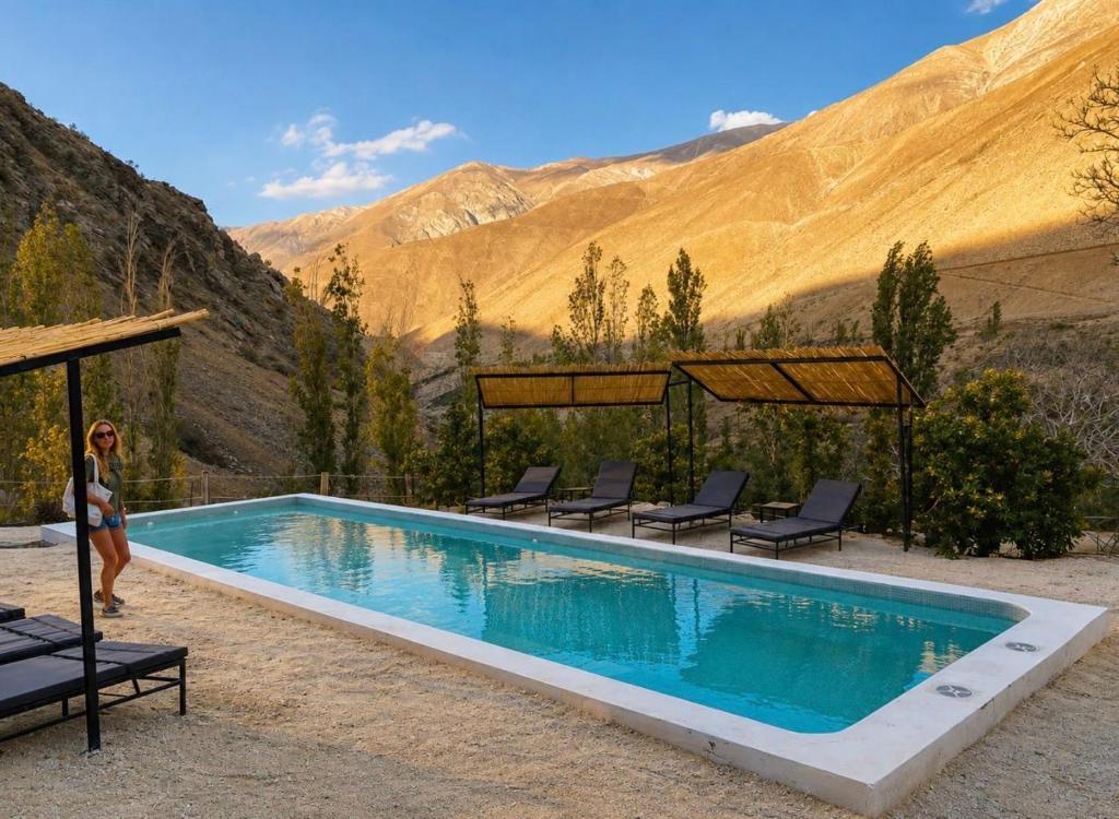 a woman is standing next to a swimming pool at Glaciar de Roca Lofts in Horcon