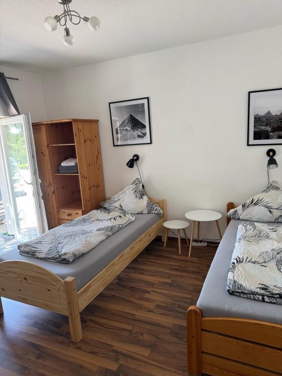 a bedroom with two beds and a table at Gästehaus Kerle in Dossenheim