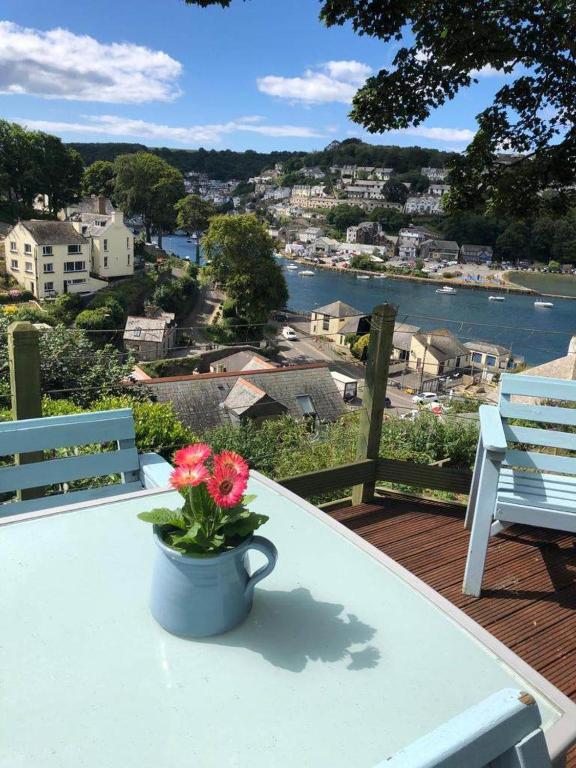 un vaso con fiori appoggiato su un tavolo su un balcone di Riverbella a Looe