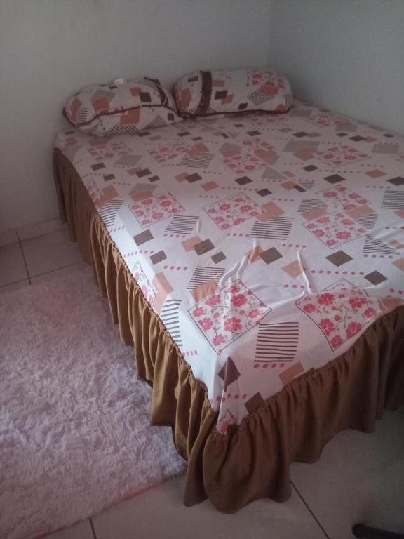a bed with a quilt on it in a bedroom at Leandra in Ponta Porã
