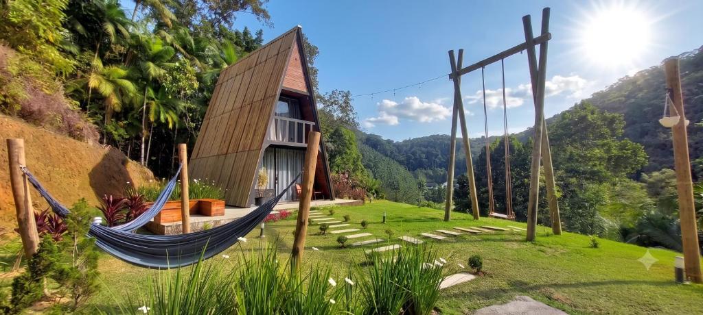 a house on a hill with a hammock at Chalé Exclusivo Com Hidro em Meio a Natureza in Blumenau
