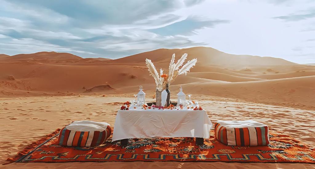 a table in the middle of the desert at Sahara Nomadic Luxury Camp in Merzouga