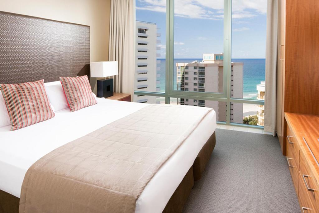 a bedroom with a large bed with a view of the ocean at Mantra Legends Hotel in Gold Coast