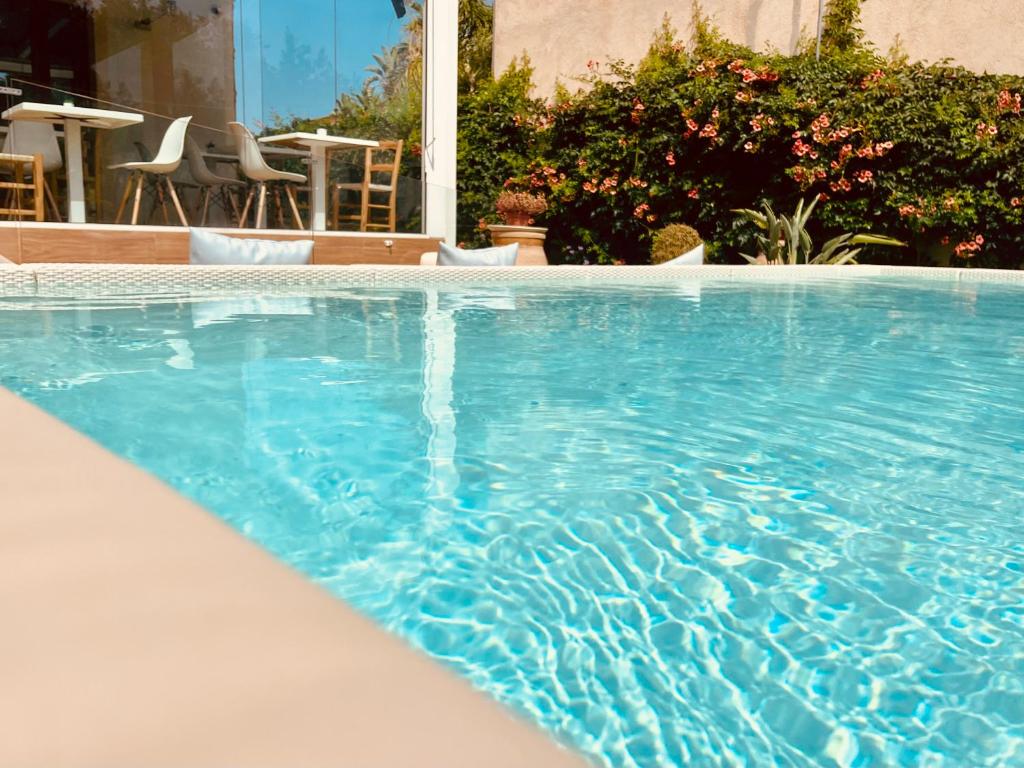 a swimming pool with blue water in a yard at Ricordi Siciliani - Charme Rooms in San Vito lo Capo