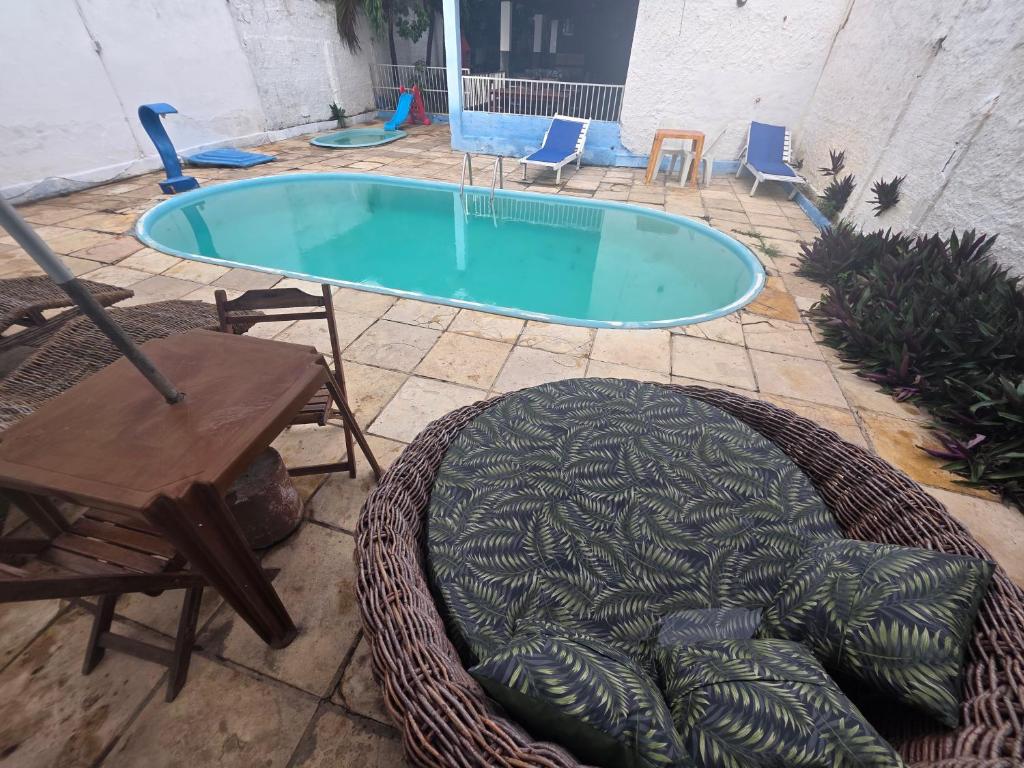 a swimming pool with a table and chairs and a chair at Capitolio 02 in Canoa Quebrada