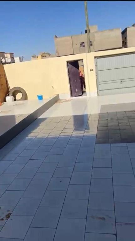 a room with a tiled floor and a building at Chez YaZ in Nouakchott