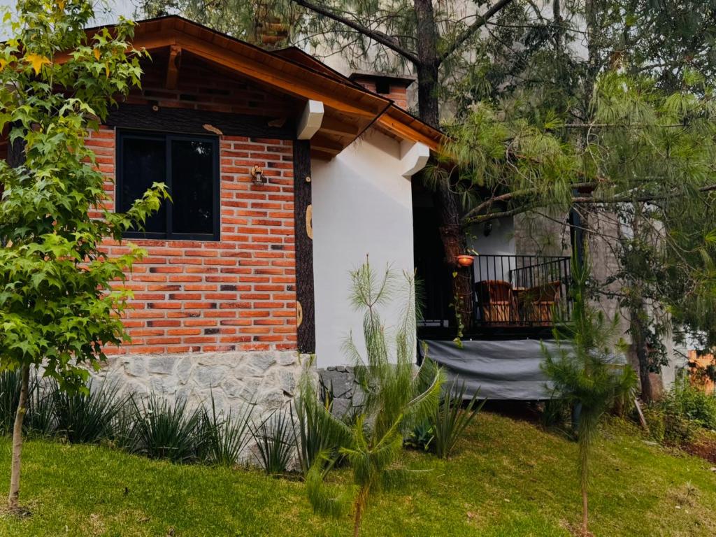a brick house with a window and a balcony at Cabaña el roble, Mazamitla Jalisco in Mazamitla