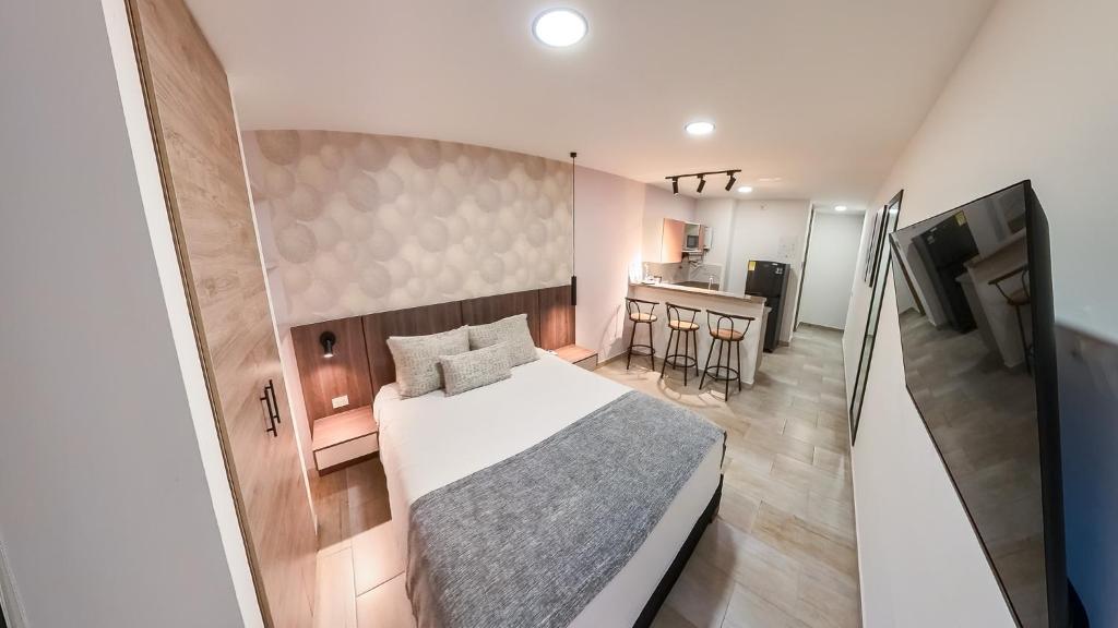 a small bedroom with a bed and a kitchen at Hotel Molinos by Growing Group in Medellín