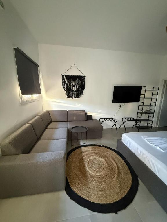 a living room with a couch and a bed at Coconut beach villas 4 in Schinias