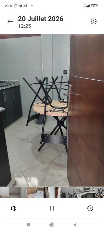 a table and chairs in a room with a refrigerator at Résidence Hala in Tan-Tan