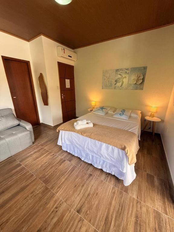 a bedroom with a large bed in a room at Agradável Kitnet próximo à Praia do Forte in Mata de Sao Joao