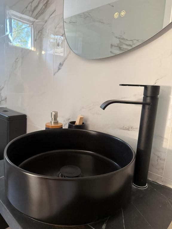 a black sink in a bathroom with a mirror at Coconut beach villas 5 in Schinias