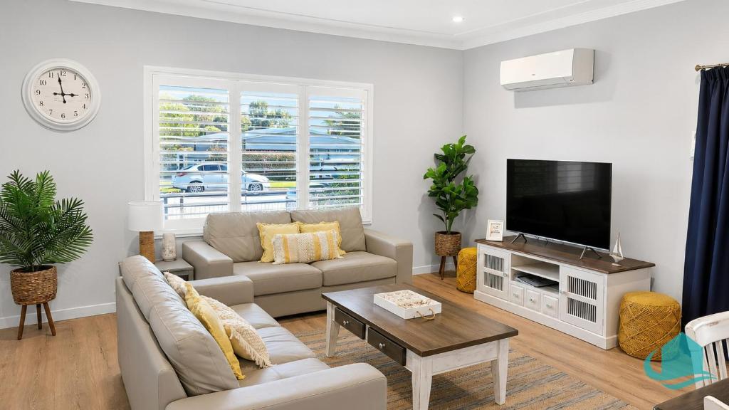 a living room with a couch and a tv at Castaway at Pelican in Pelican Flat