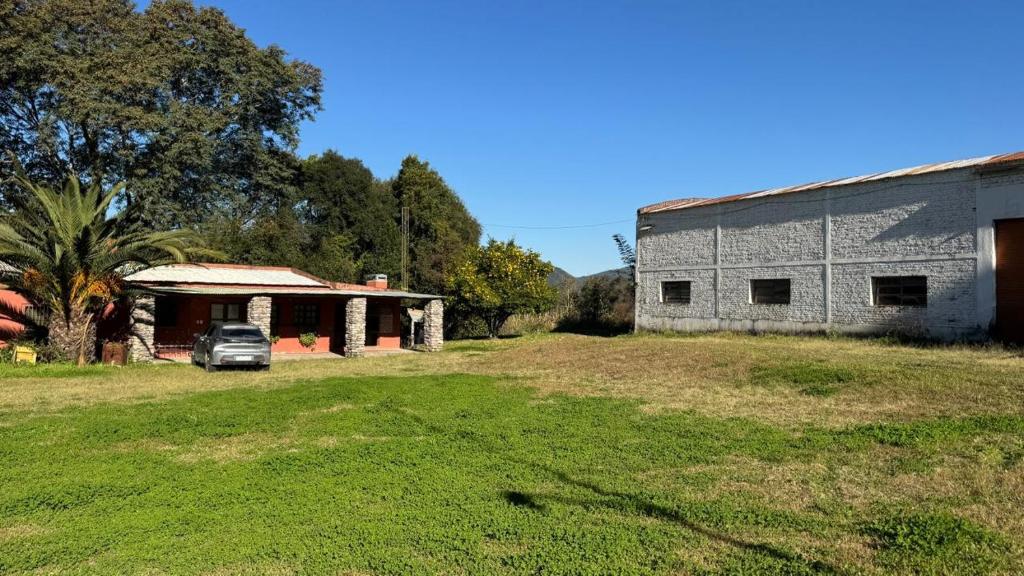 an old building with a car parked in a yard at Kallpa Warmi in San Antonio