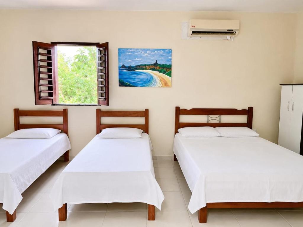 a room with three beds and a window at Rooftop na lagoa in Jijoca de Jericoacoara
