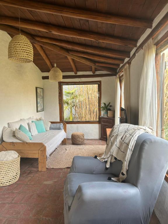 a living room with a bed and a couch at La Cabaña de Caro in Mar de Cobo