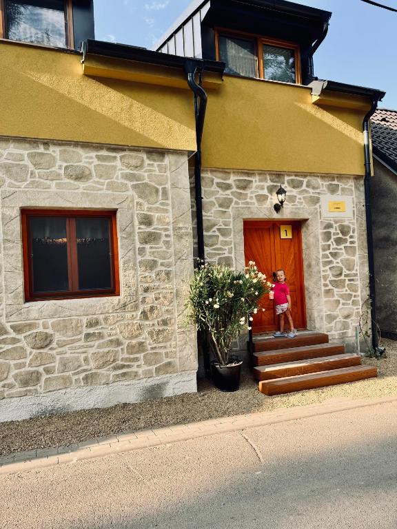 a woman standing in front of a house at Ubytování U Špíšků in Jaroslavice