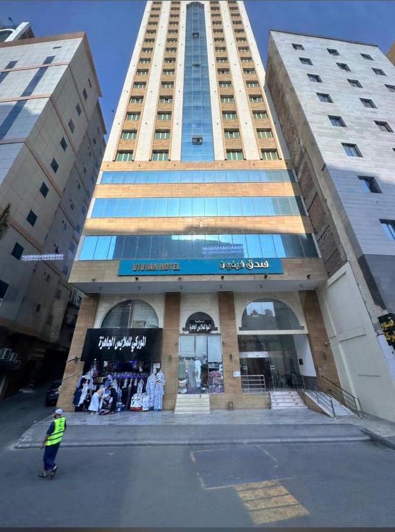 a man standing in front of a tall building at فندق فيفيان الجميزة in An Naqāʼ