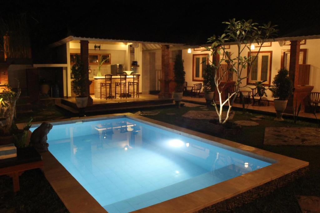 una piscina en un patio trasero por la noche en Casa D'Sami B & B, en Ubud