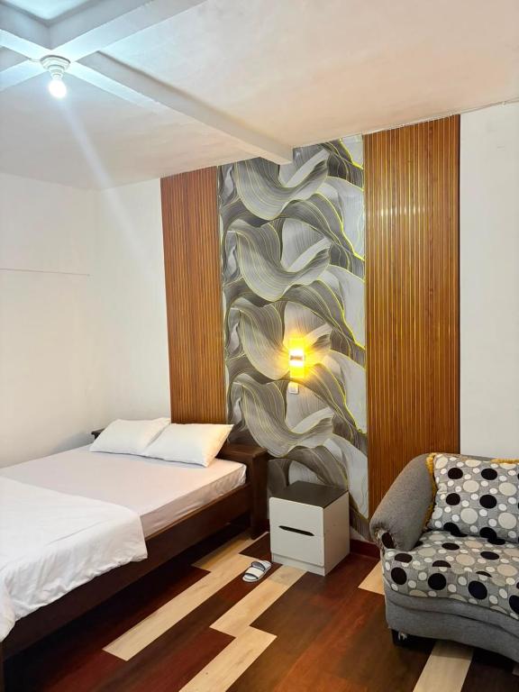 a bedroom with a bed and a chair in it at Homestay Anugerah Tumpak sewu in Lumajang