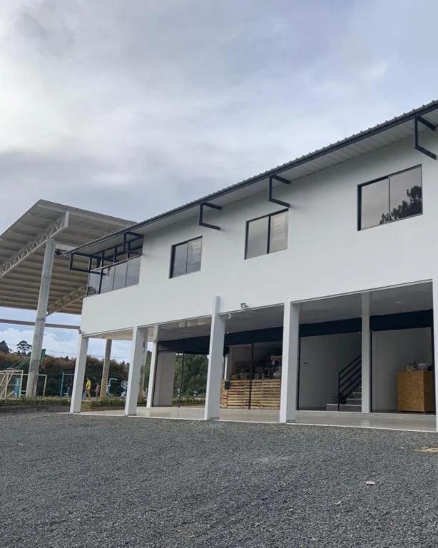 a white building with windows on the side of it at Refugio raices in Guarne