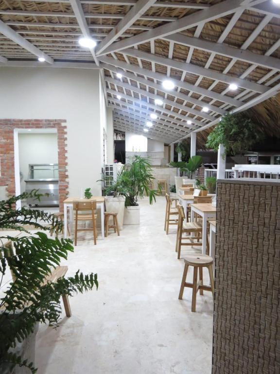 a room with tables and chairs and plants in it at Yara Hotel in Punta Cana