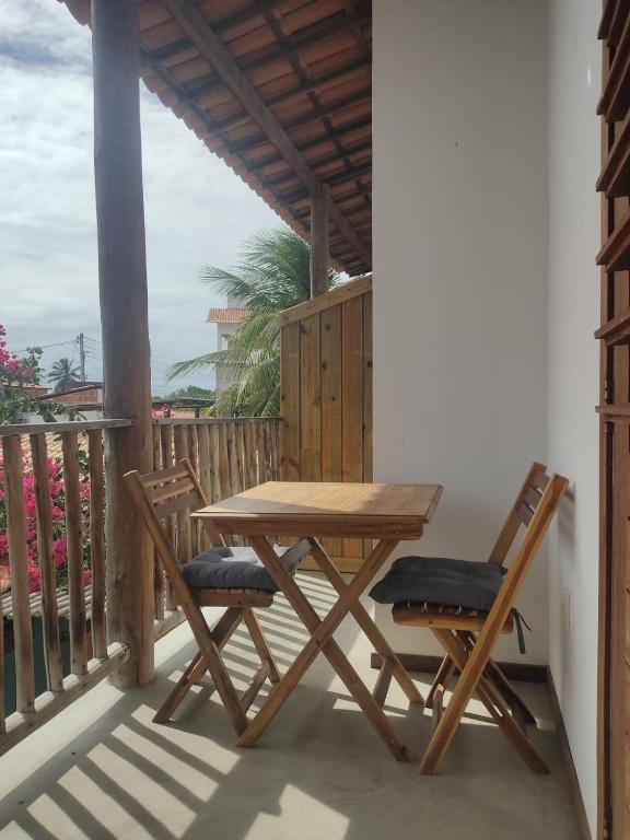 a wooden table and two chairs on a balcony at Prédio em praça pontal de Maceió in Fortim