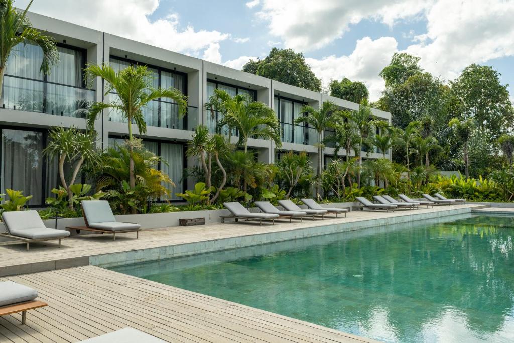 an exterior view of a hotel with a swimming pool at Ecoverse Resort & Residence by OXO - Nyanyi Beach, Bali in Cemagi