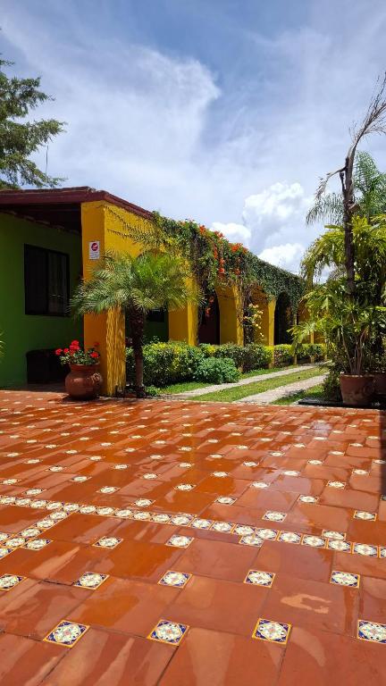 a courtyard with a yellow building with flowers on it at Hotel Sicarú in Chapulco