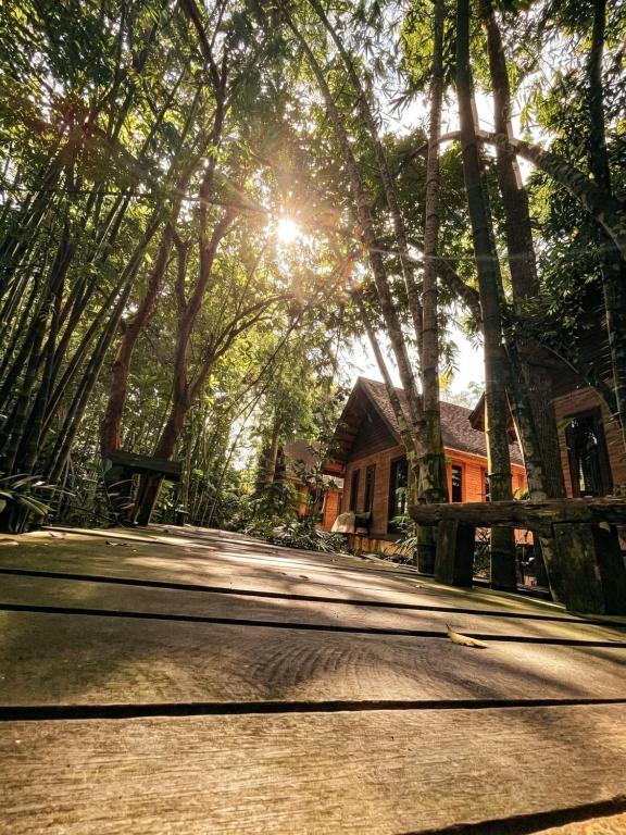 a house with the sun shining through some trees at Kung Nok Tha Resort Nakhon Si Thammarat in Nakhon Si Thammarat