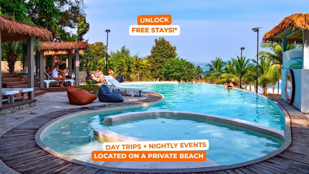 a large pool at a resort with people sitting around it at Mad Monkey Koh Sdach in Kaoh Sdach
