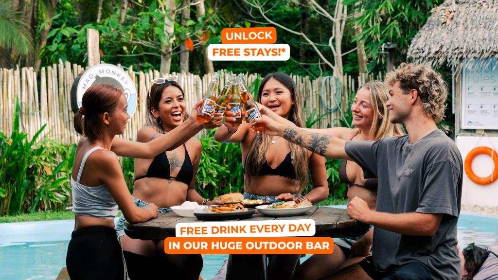 a group of women holding up glasses of beer at Mad Monkey Hostel Siargao in General Luna