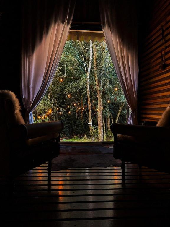 a room with a window with curtains and a couch at Ruhehaus in Arabutã