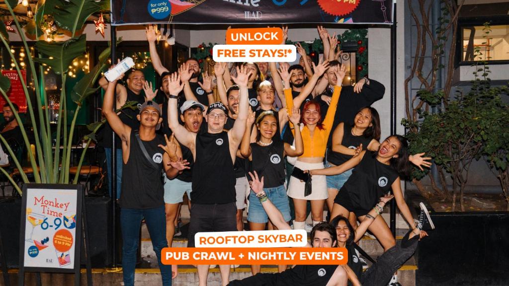 a group of people posing for a picture with their hands in the air at Mad Monkey Manila in Manila