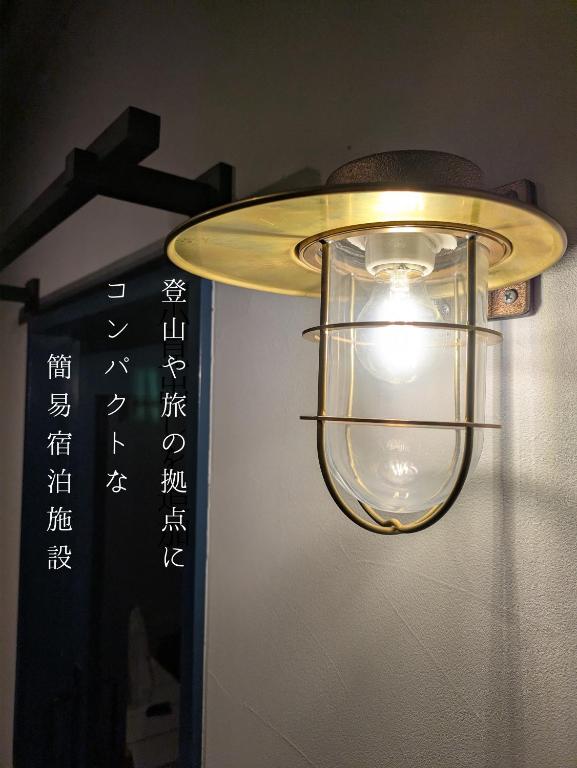 a light hanging from a wall with writing on it at Hostel x Hair ie in Hadano