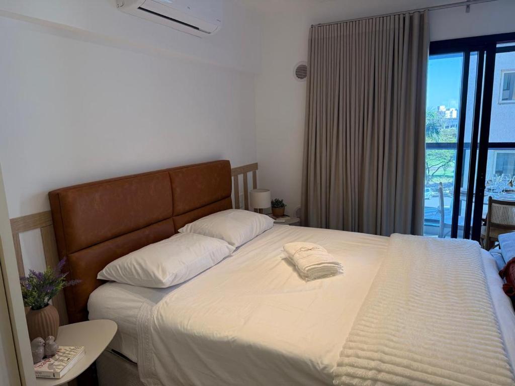 a bedroom with a large bed with white sheets at Loft Elegante proximo do Shopping Esmeralda in Marília
