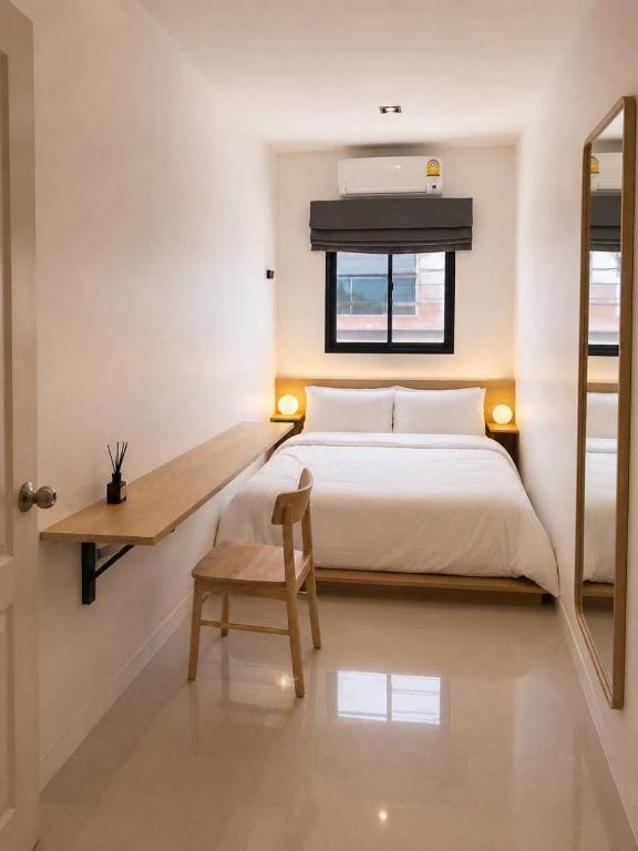 a bedroom with a bed and a chair and a window at 9 mins to BTS Queen Private Room Share Bath in Amphoe Phra Khanong