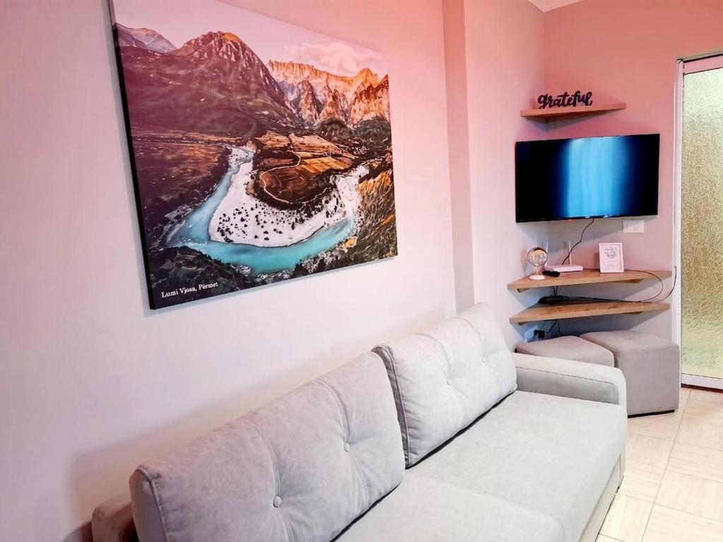 a living room with a couch and a tv at Dhimarko Guest House in Përmet