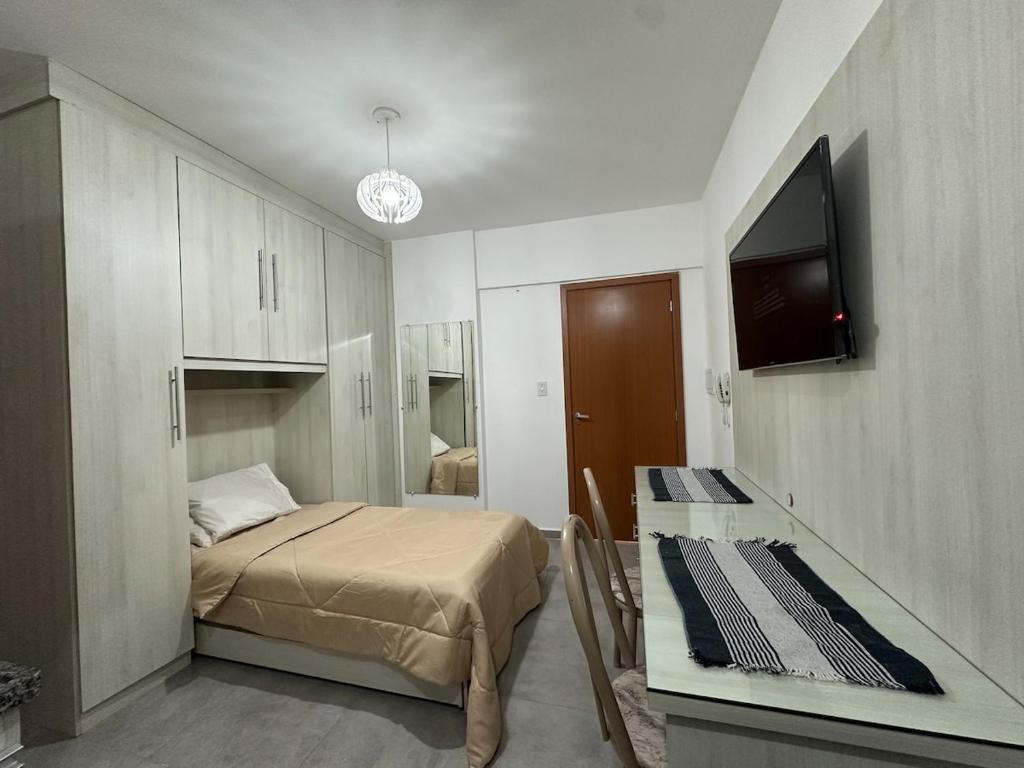a small bedroom with a bed and a tv in it at Studio Brooklyn - 3 minutos da EPCAR in Barbacena