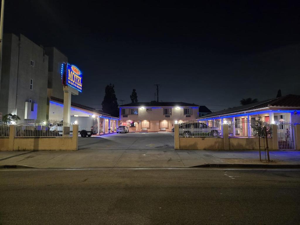 a building with a neon sign on the side of a street at Evans Motel in Maywood