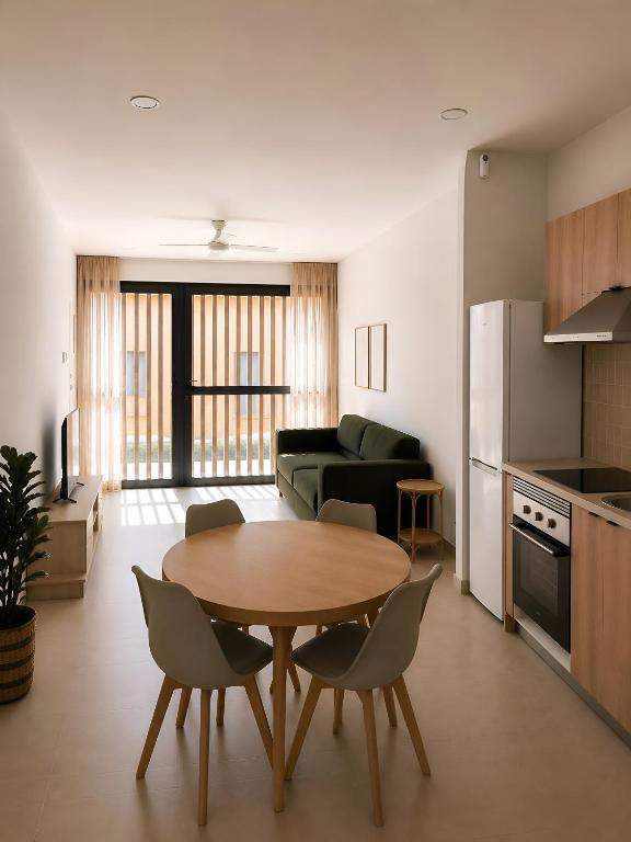 a kitchen and a living room with a table and chairs at APARTAMENTO LEPANTO in Almazora